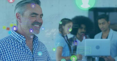 Smiling senior colleague engaging with diverse team in digital workplace