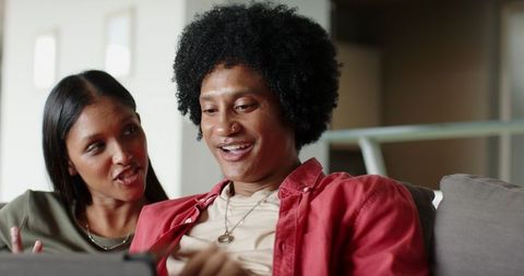 Diverse Couple Engaged in Tablet Viewing at Cozy Home