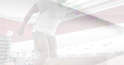 Male athlete jumping plyo box in bright gym interior for plyometrics and cardio training