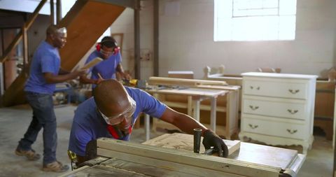 African american carpenters working in woodwork workshop