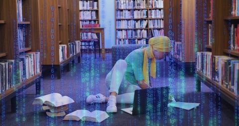Young Woman in Yellow Headscarf Studying with Laptop in Library with Digital Code Overlay