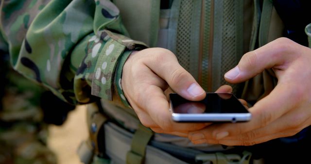 Soldier in camouflage uniform using smartphone in field - Download Free Stock Images Pikwizard.com