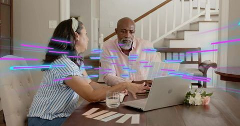 Couple collaborating over laptop and paint swatches at table with neon glitch overlay