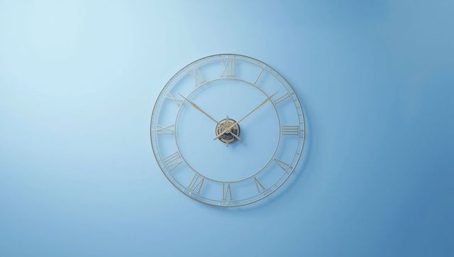 Skeleton wall clock with roman numerals against blue wall