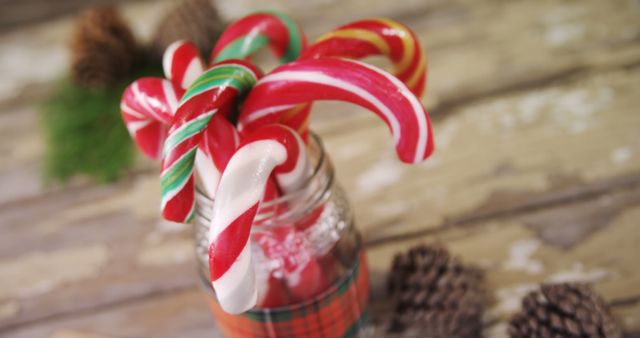 Candy canes in a festive jar evoke the sweet and cozy atmosphere of holiday celebrations, with copy space. Their vibrant red and white stripes are synonymous with Christmas cheer and winter festivities.