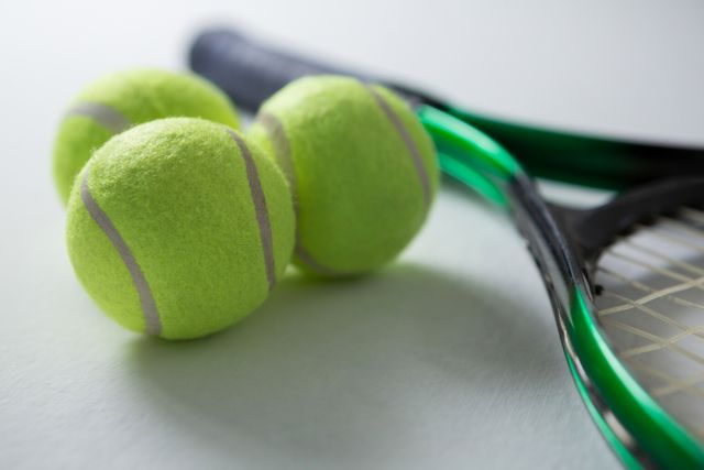 Close up of tennis balls with racket on white background