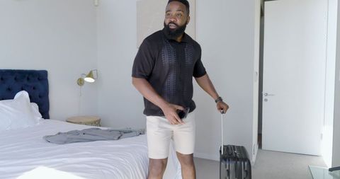 Traveler with Smartphone and Suitcase in Hotel Bedroom