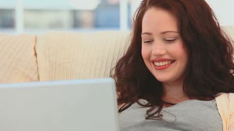 Relaxed Woman Smiling While Using Laptop