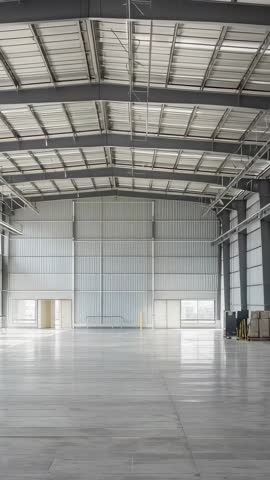 Vertical panning revealing empty industrial warehouse with central ladder and pallet stacks
