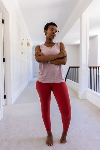 Confident african woman standing with crossed arms in bright minimalist hallway interior