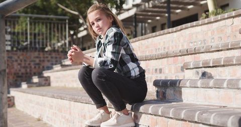 Young Girl Sitting on Brick Steps Outdoors