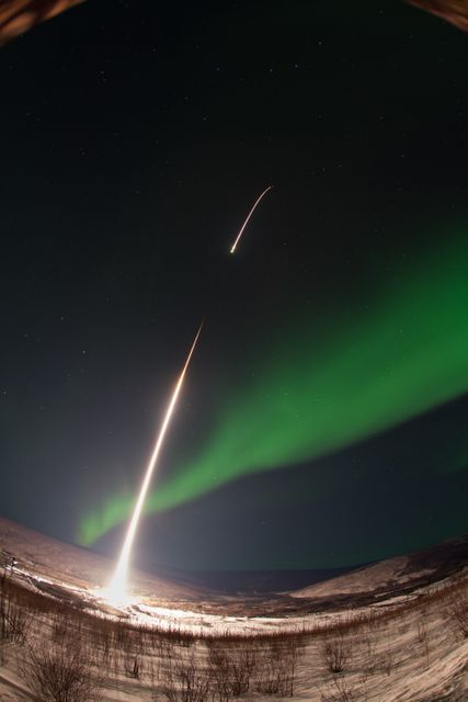 This striking scene depicts a NASA-funded sounding rocket piercing through an aurora in the early hours over Venetie, Alaska. The GREECE mission, performed on March 3, 2014, focuses on studying detailed structures within the aurora. Ideal for content on scientific research, atmospheric phenomena, and space exploration.