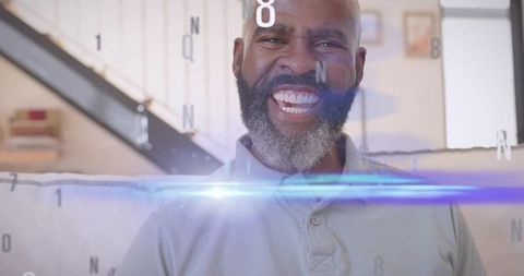 Smiling mature man relaxing on sofa with blue lens flare and alphanumeric digital overlay