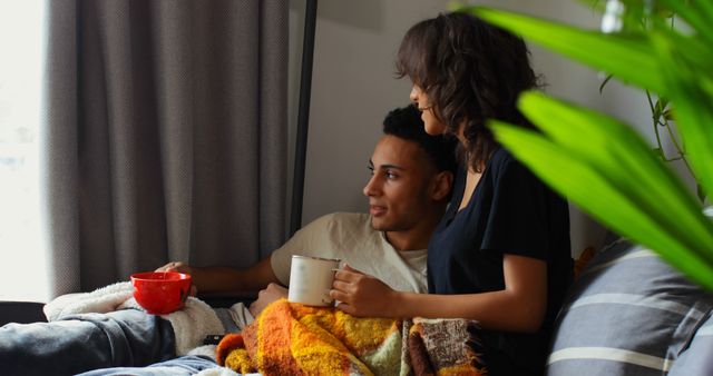 Couple Relaxing on Couch with Hot Drinks and Blanket - Download Free Stock Images Pikwizard.com