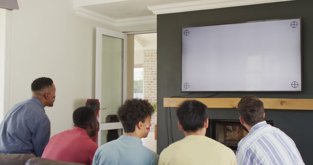 Happy diverse male friends watching tv with copy space in living room - Download Free Stock Photos Pikwizard.com