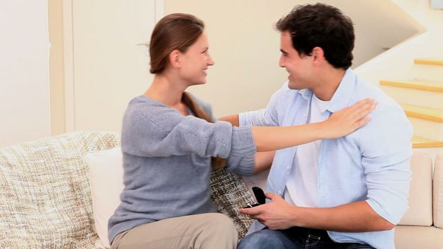 Couple sharing a joyful moment during an engagement at home. Could be used for topics related to relationships, marriage proposals, love, romantic moments, and lifestyle blogs.