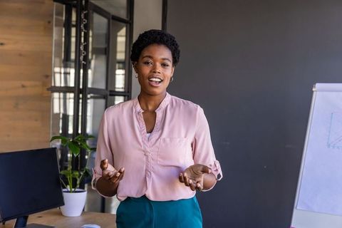 Confident black woman leading office presentation
