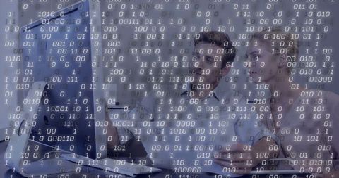 Collaborating professionals analyzing digital code on screen