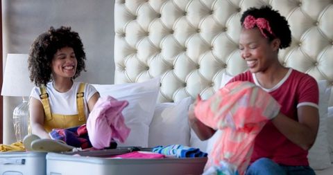 Diverse Female Couple Packing Suitcases for Fun Getaway