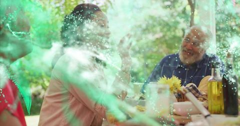 Multigenerational Family Enjoying Sunlit Garden Lunch with Bread, Olive Oil, Yellow Flowers