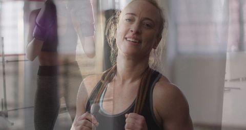 Smiling Athletic Woman with Jump Rope in Gym Reflecting Inner Strength