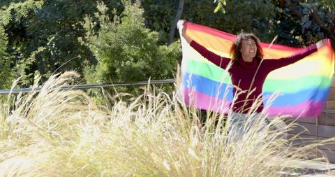 Woman Celebrating Diversity with Vibrant Rainbow Flag