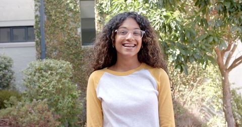 Smiling Teenage Girl Enjoying Sunny School Courtyard Moment
