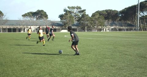 Youth soccer athletes enhancing teamwork on green field