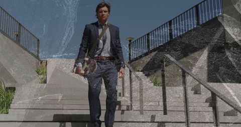 Businessman in suit descending stairs with messanger bag