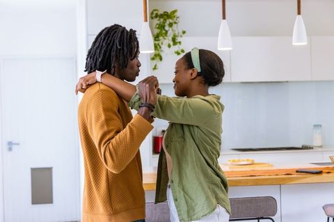 African American Couple Embracing on Bright Minimalist Kitchen Island, Casual Home Moment