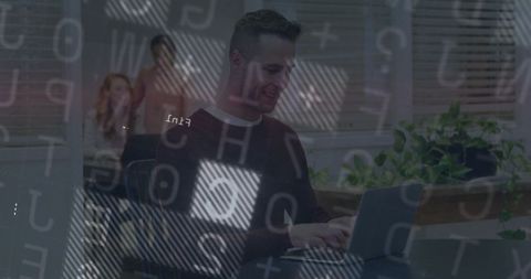 Focused professional typing on laptop with team in modern office