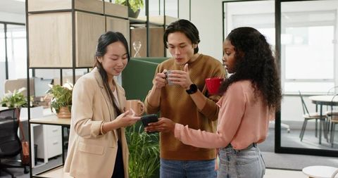Diverse Team Discussing Ideas in Modern Office over Coffee