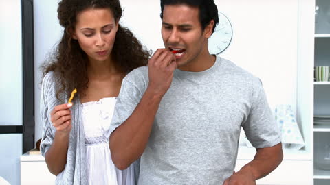 Couple Cooking and Sharing Vegetables Together in Modern Kitchen
