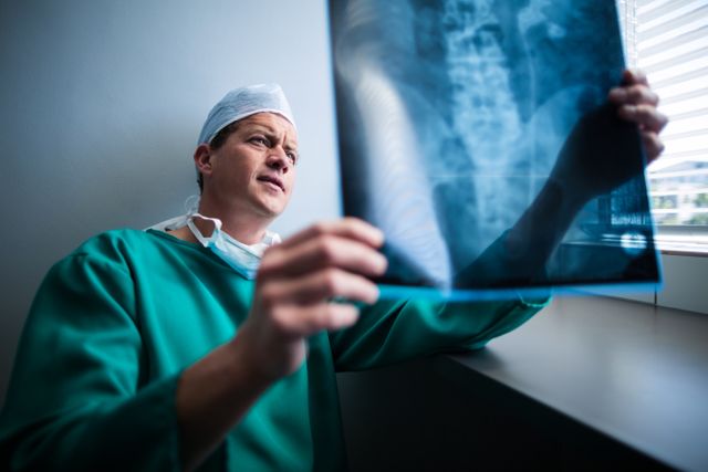 Surgeon Examining X-ray Near Window in Hospital - Download Free Stock Photos Pikwizard.com