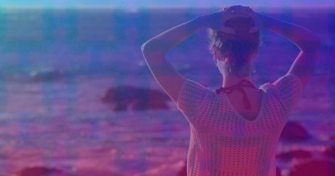 Woman relaxing by sea with artistic overlay at dusk