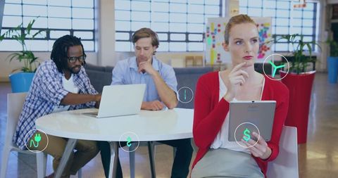Woman thinking with tablet while team collaborating in bright modern coworking space