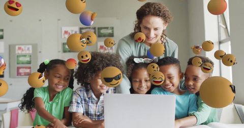 Happy schoolchildren and teacher engaging with emoticons on laptop