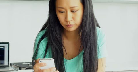 Asian woman engaged on smartphone in modern setting