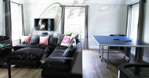 Modern game-ready living space with dark gray l-shaped sectional and ping pong table