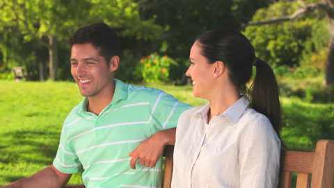 Happy Couple Enjoying Relaxing Moment on Sunny Park Bench