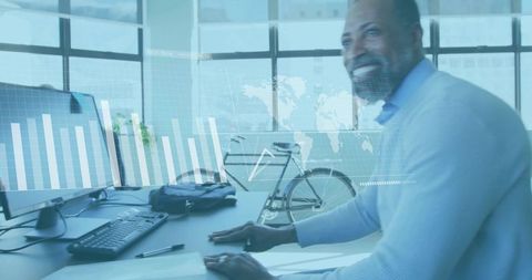 Mature professional analyzing financial charts on office monitor with bicycle