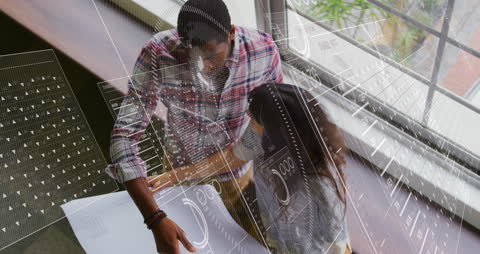 Diverse Coworkers Reading Blueprint in Modern Office