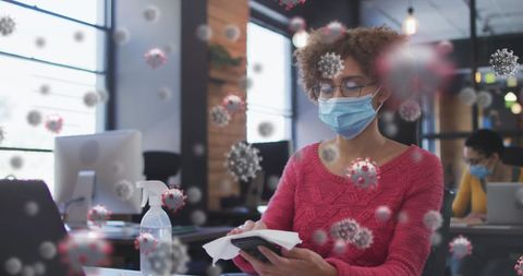 woman wearing mask in office cleaning smartphone with safety precautions - Download Free Stock Images Pikwizard.com