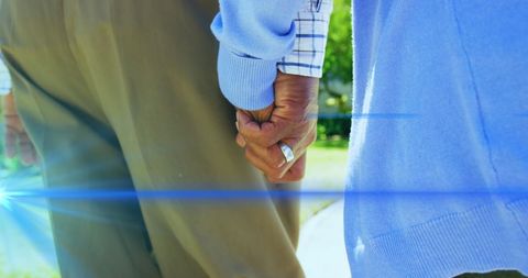Senior Couple Holding Hands with Lens Flare Effect