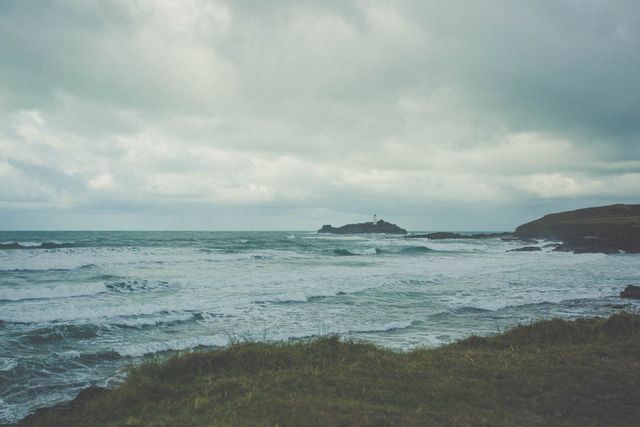 Overcast Coastal Landscape with Distant Lighthouse - Download Free Stock Photos Pikwizard.com