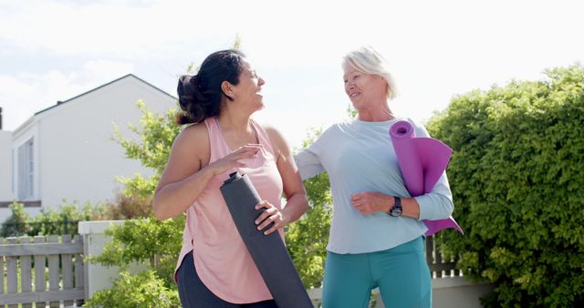 Smiling women with yoga mats standing outdoors enjoying conversation - Download Free Stock Images Pikwizard.com