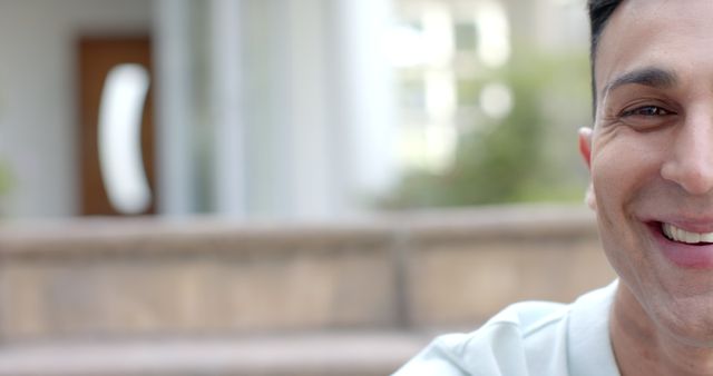 Close-up of smiling man sitting outdoors against blurred building - Download Free Stock Images Pikwizard.com