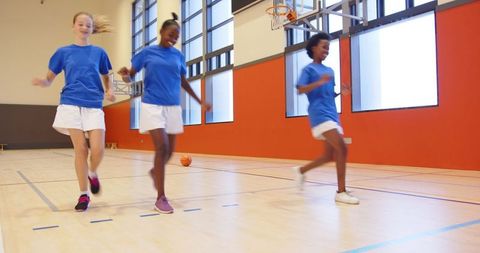 Diverse team of girls engaging in energetic school gym activity