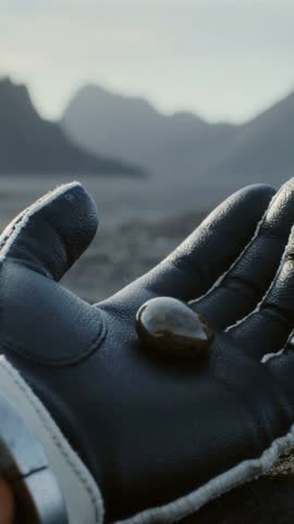 Closeup Gloved Hand Presenting Polished Stone Against Mountain Horizon | Vertical Video