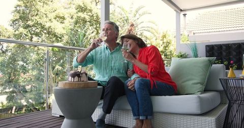 Senior Couple Celebrating on Patio with Wine and Cake